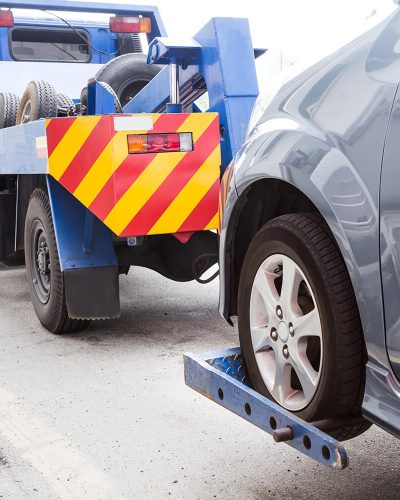 tow-truck-towing-a-broken-down-car-on-the-street-PE9HH3A.jpg